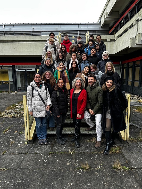Schülergruppe steht auf einer Treppe an der Uni Bremen mit der Professorin Karakasoglu