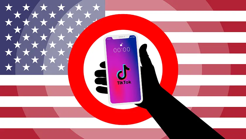 Hand mit einem Handy vor der US-Flagge mit rotem Stoppschild